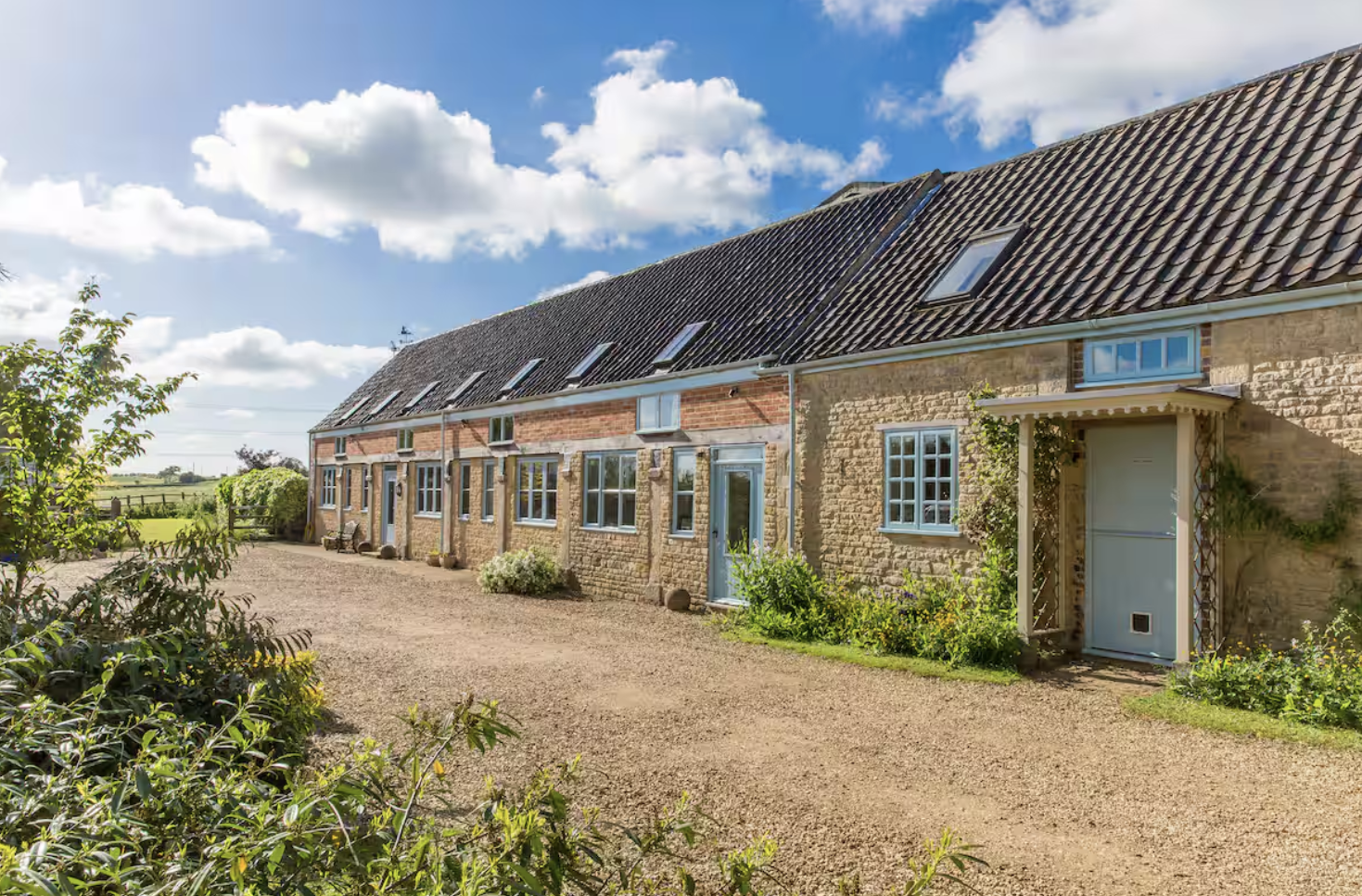 Piper House, a long Lincolnshire farmhouse with pale blue window frames under a blue sky