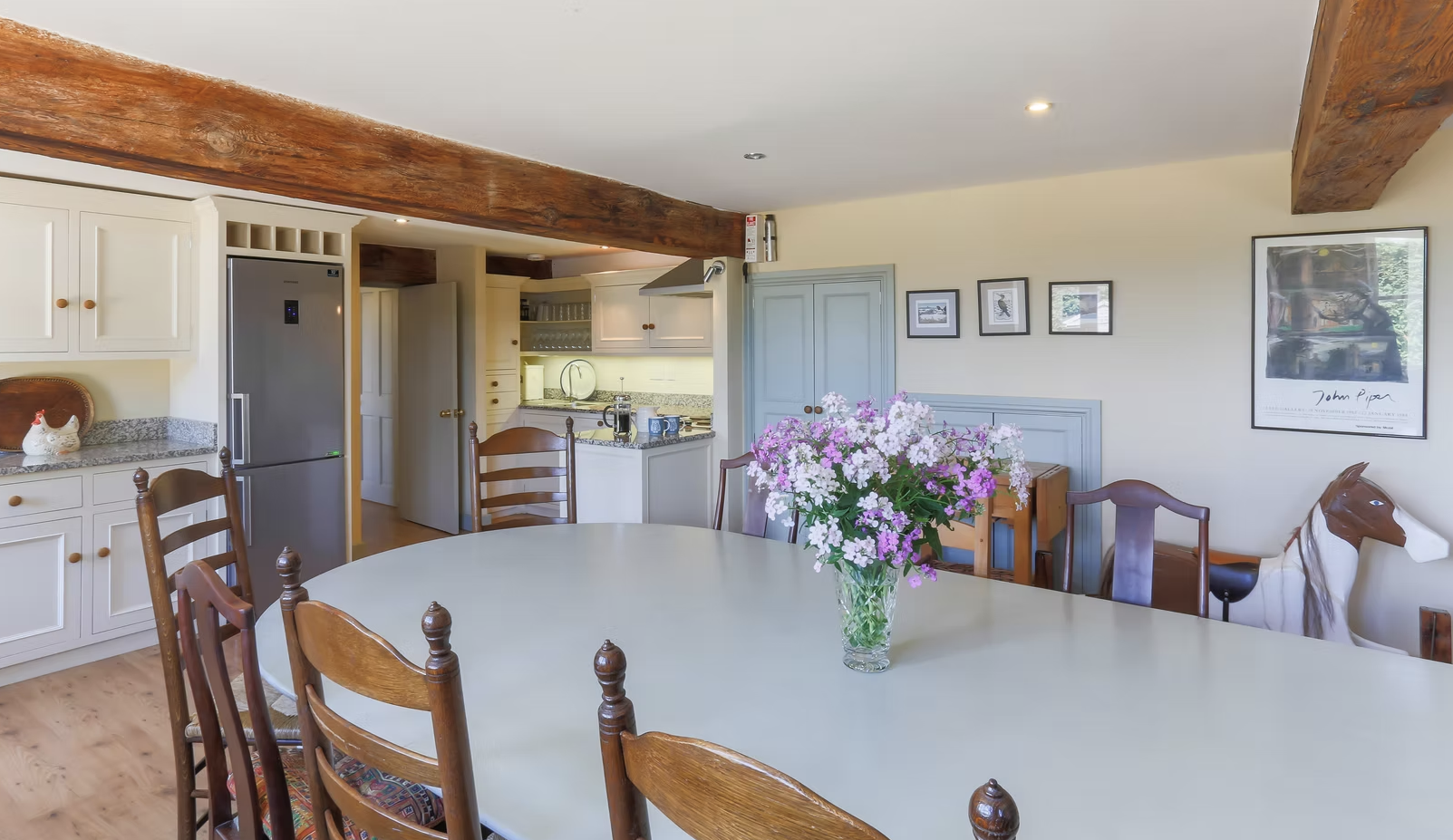 Country kitchen with a large dining table and fresh flowers